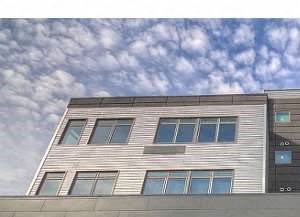 a building with many windows and a cloudy sky