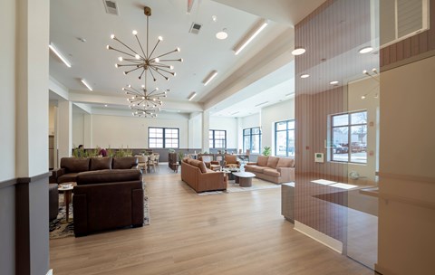 A modern living room with brown furniture and a chandelier.