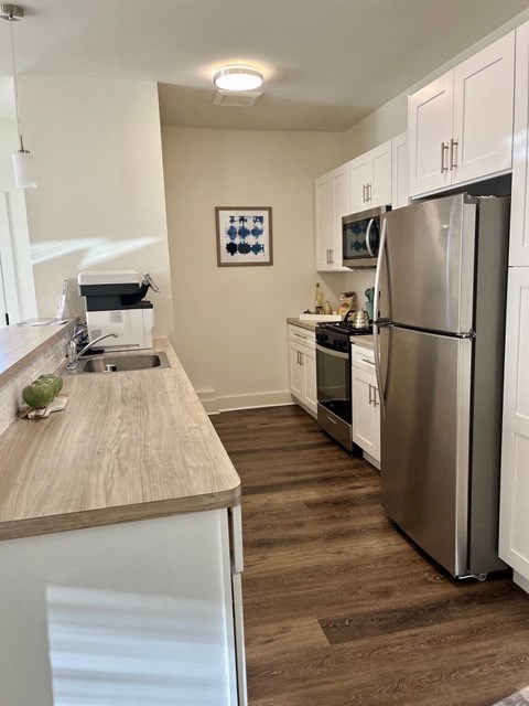 a kitchen with stainless steel appliances and a wooden counter top