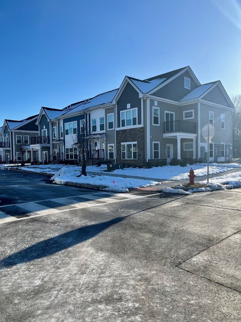 an apartment building with a red fire hydrant in the snow
