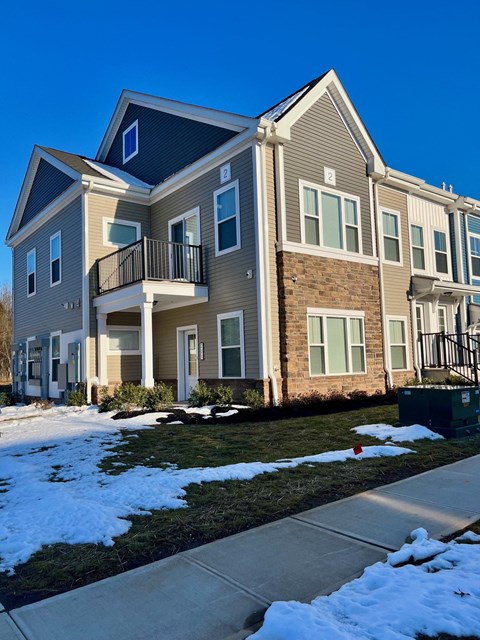 an apartment building with a snow covered sidewalk