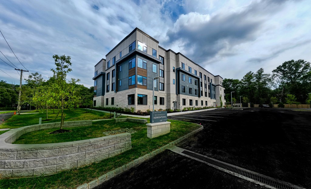 A modern building with a parking lot in front.