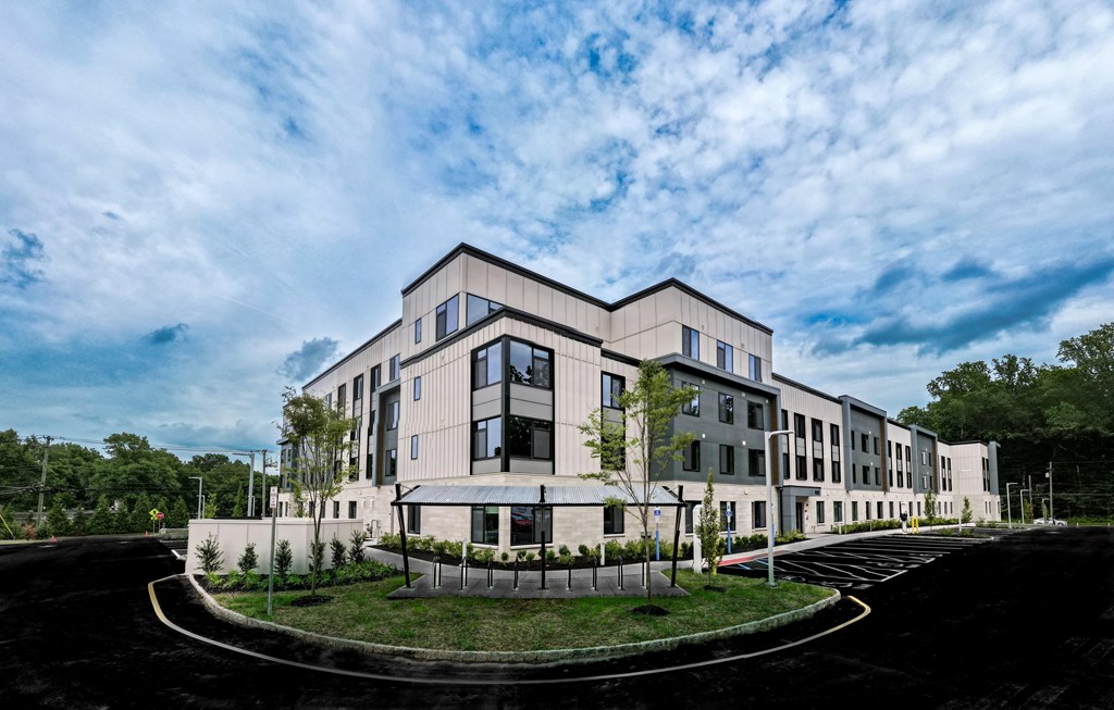 A modern building with a curved driveway in front.