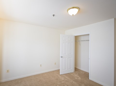a bedroom with a white door and a closet
