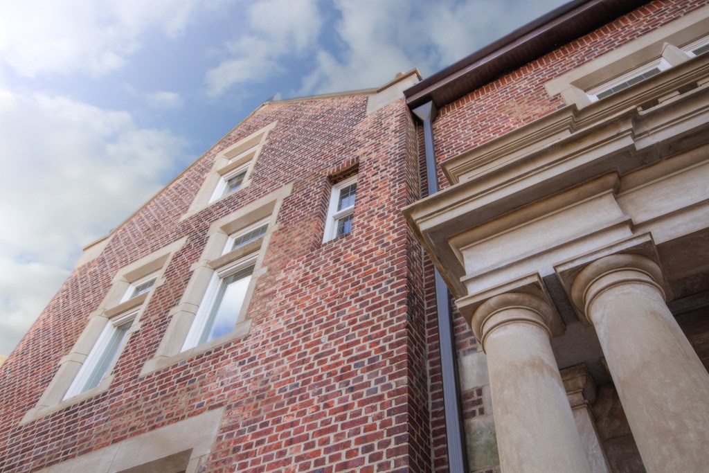 the facade of a brick building with columns and windows