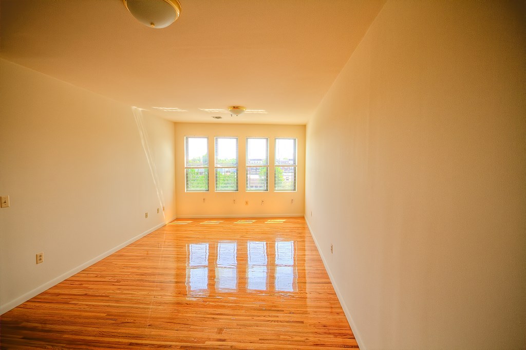 a empty living room with wooden floors and a window