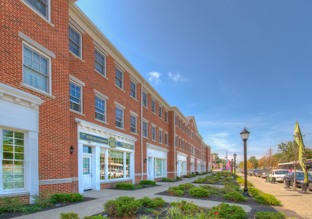 a large brick building with a sidewalk in front of it