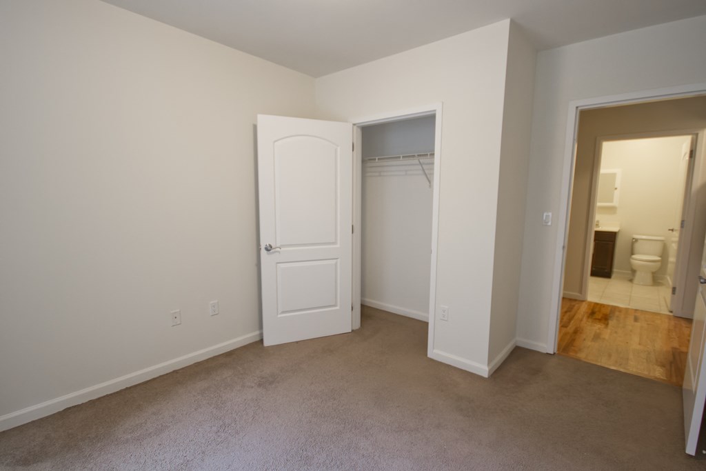 a bedroom with a closet and a door to a bathroom