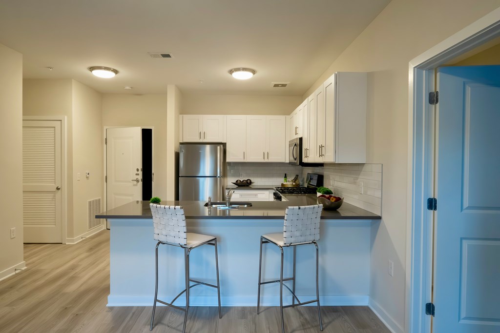 A kitchen with a bar stool and a counter.