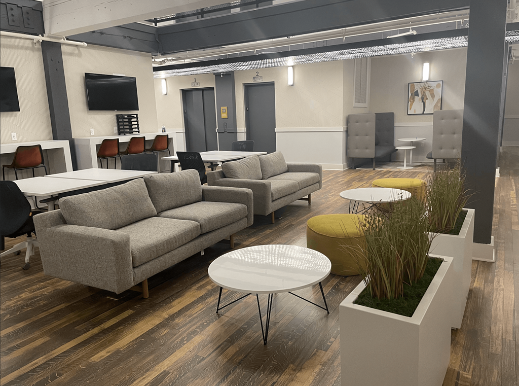 a lounge area with couches tables and chairs and a tv