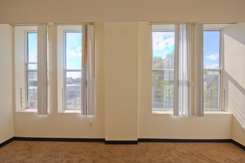 a living room with four windows and a carpet
