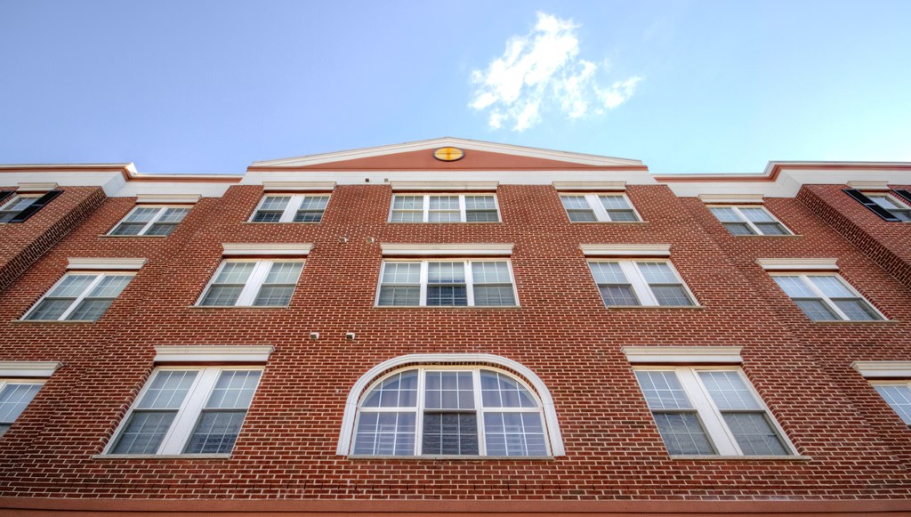 a red brick building with windows and a blue sky