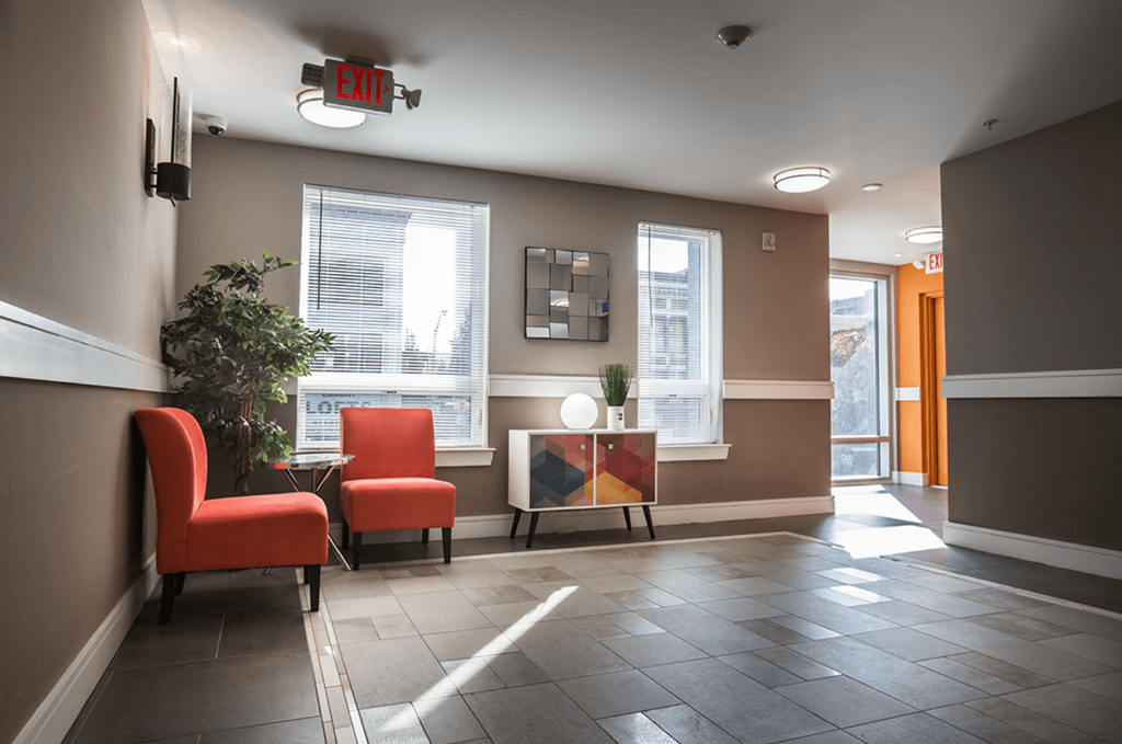 a lobby with two red chairs and a table