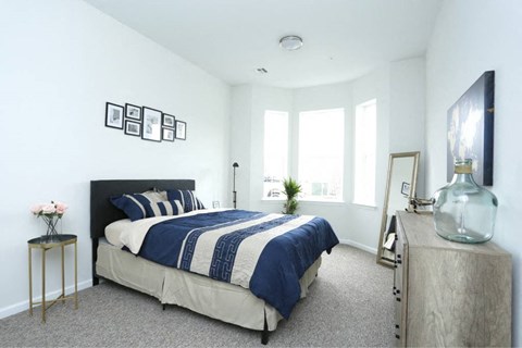 a bedroom with a bed and a large window