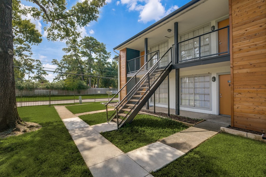 a house with a yard and a staircase in front of it