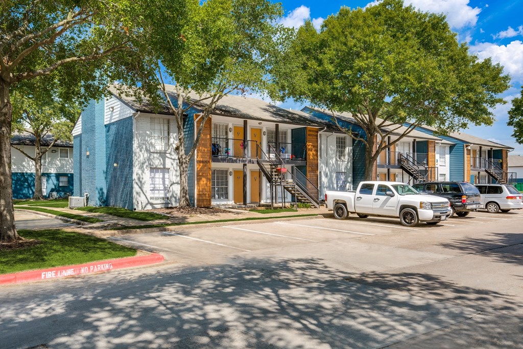 a row of houses with cars parked in front of them