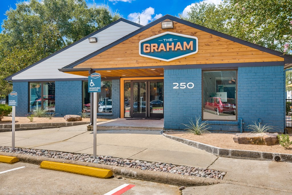 the front of the graha car dealership with a blue brick building with a wood