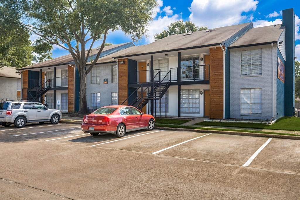 a red car parked in front of an apartment building