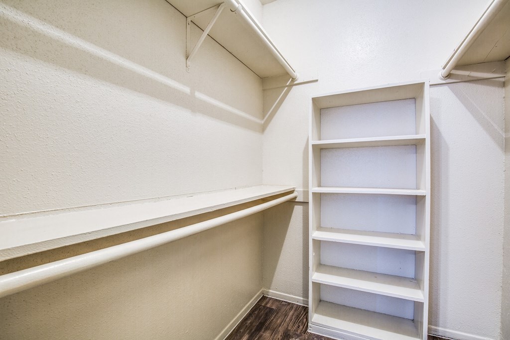 a walk in closet with shelves and empty shelves