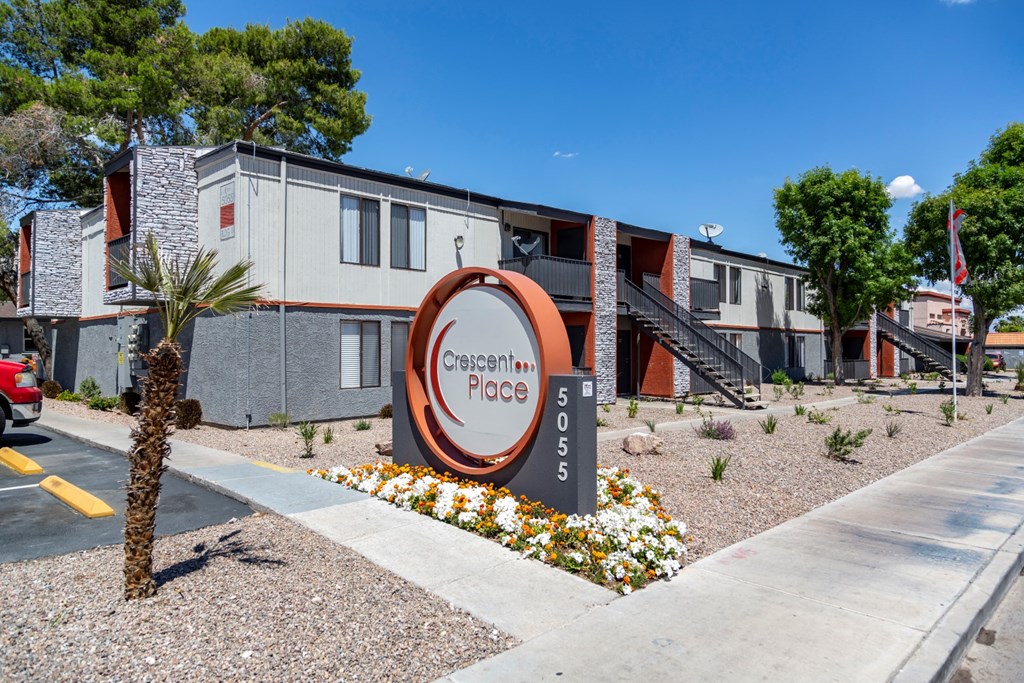a building with a sign and flowers in front of it