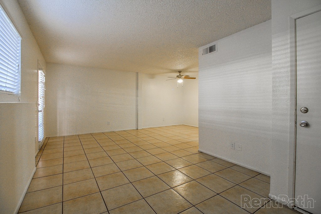 the living room of a house with a tiled floor and a white door