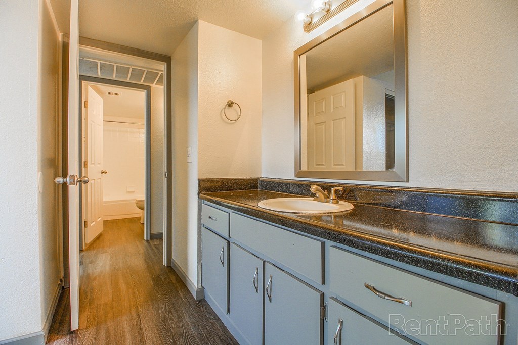 a bathroom with blue cabinets and a sink and a mirror