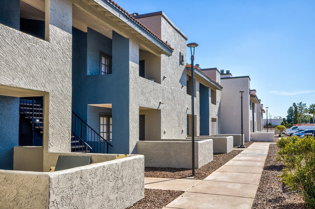 a row of townhomes with blue and white buildings and a sidewalk