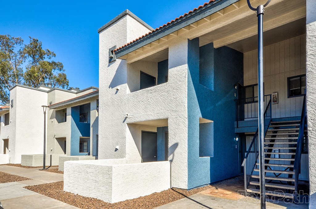 a white and blue building with stairs and a blue sky