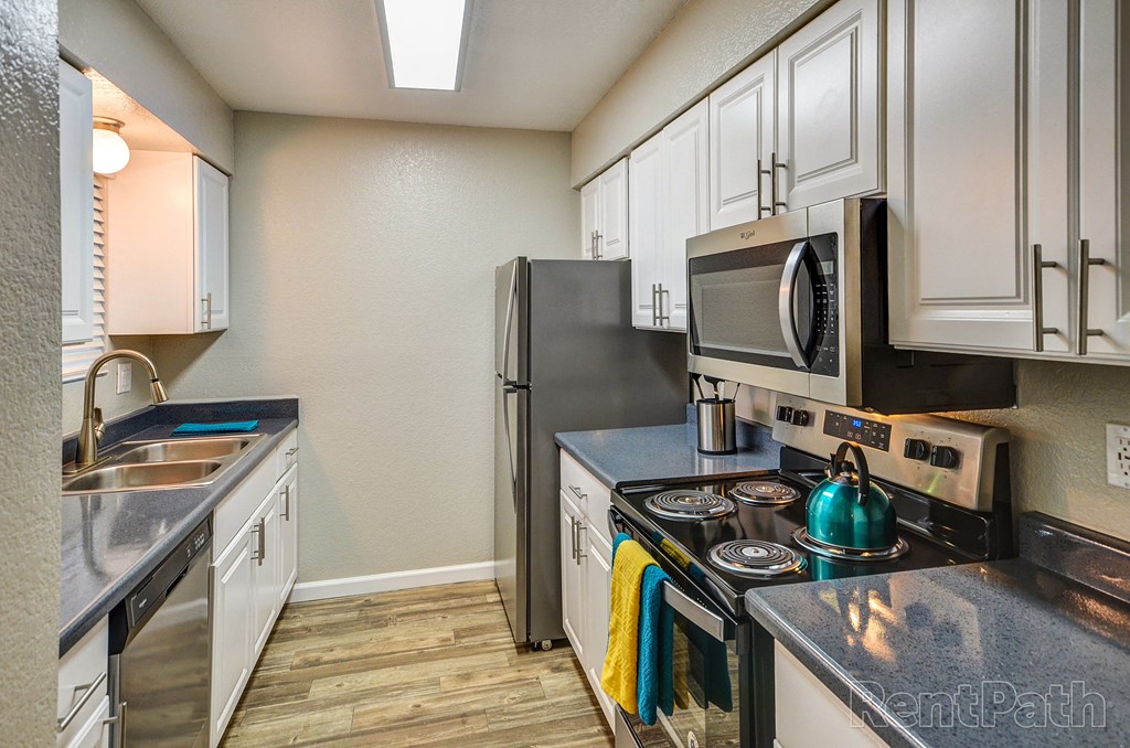 a kitchen with stainless steel appliances and white cabinets