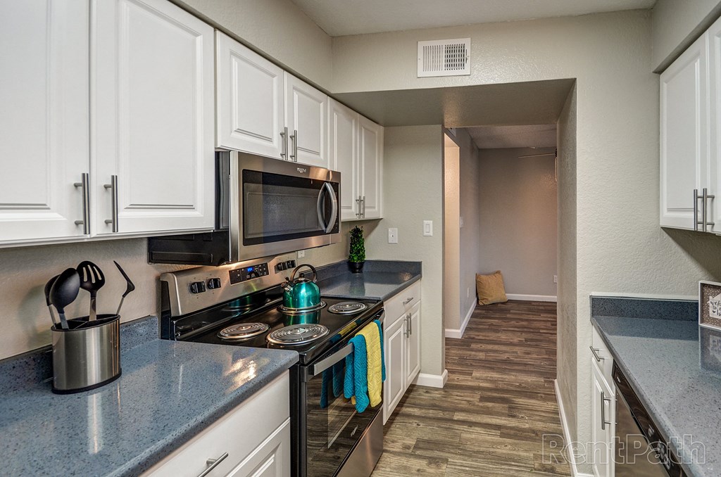 a kitchen with white cabinets and a stove and a microwave