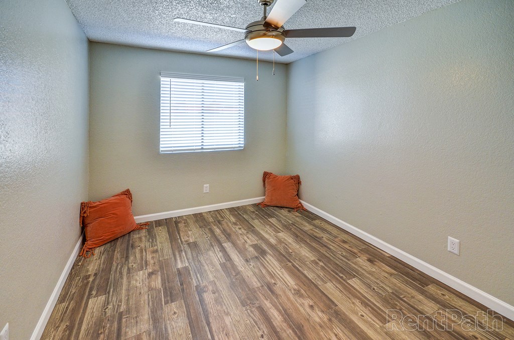 a living room with hardwood floors and a ceiling fan