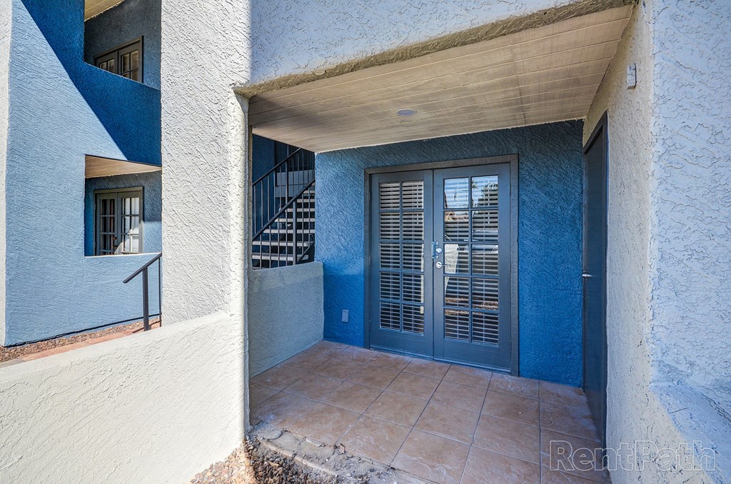 a blue door on a building with a tile floor