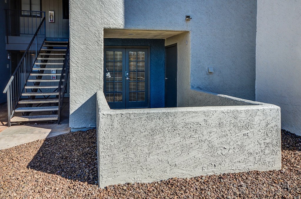 a front porch of a house with stairs and a blue door