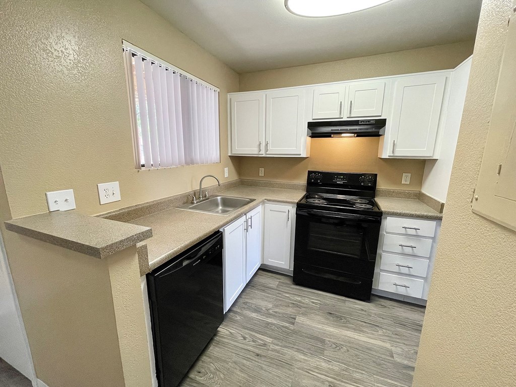 a kitchen with white cabinets and black appliances