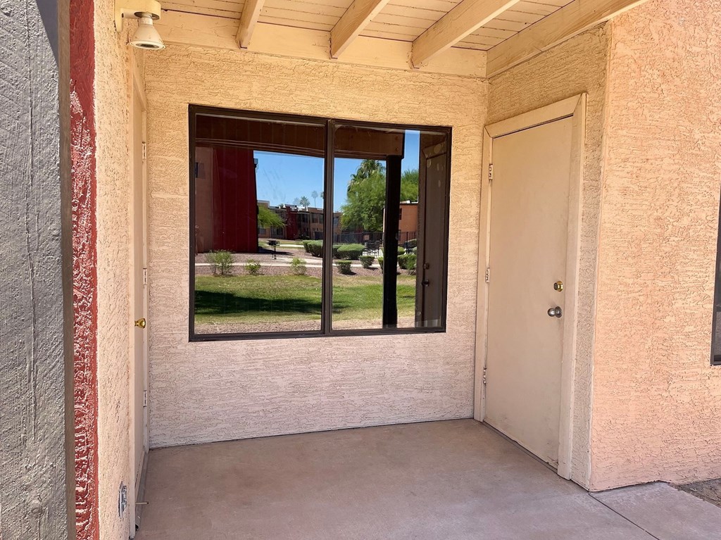 an empty room with a large window and a door