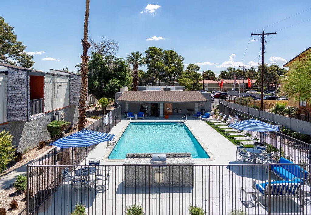a resort style pool with blue and white chairs and umbrellas