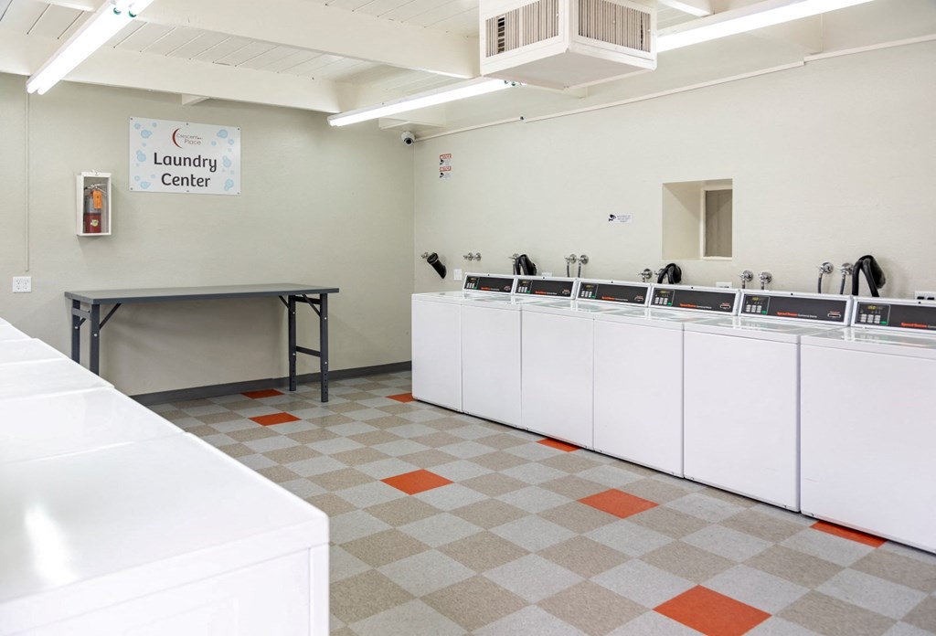 a laundry room with white cabinets and a checkered floor
