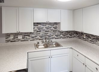 a white kitchen with white cabinets and a sink