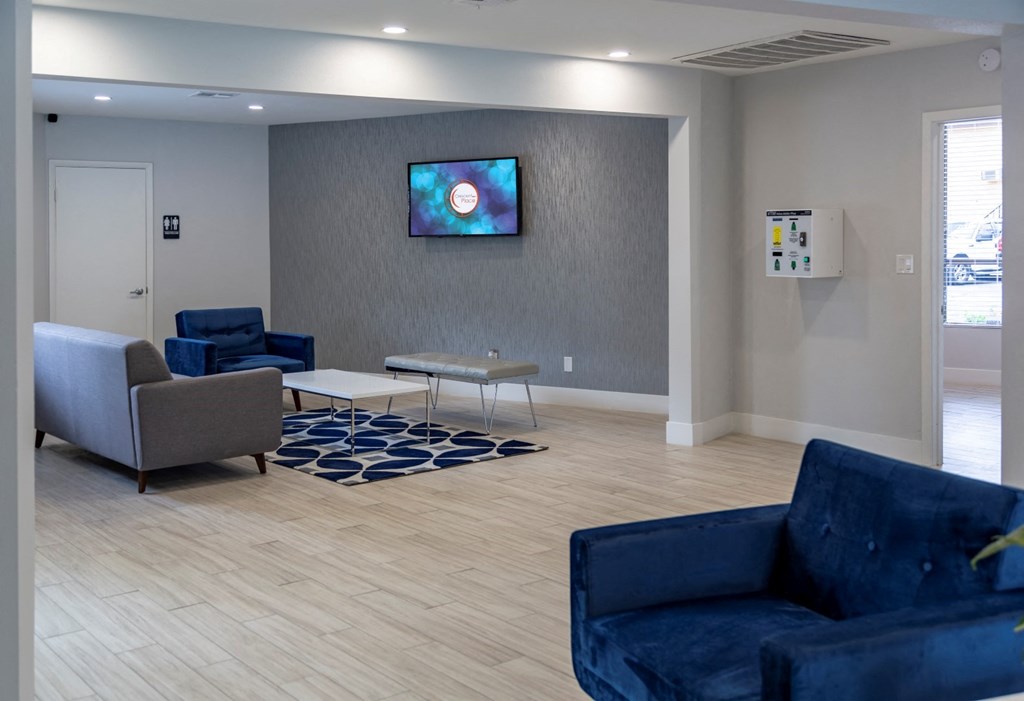 a living room with couches and chairs and a tv on the wall