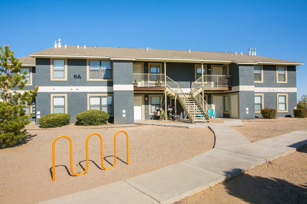 an exterior view of an apartment building with stairs and a sidewalk