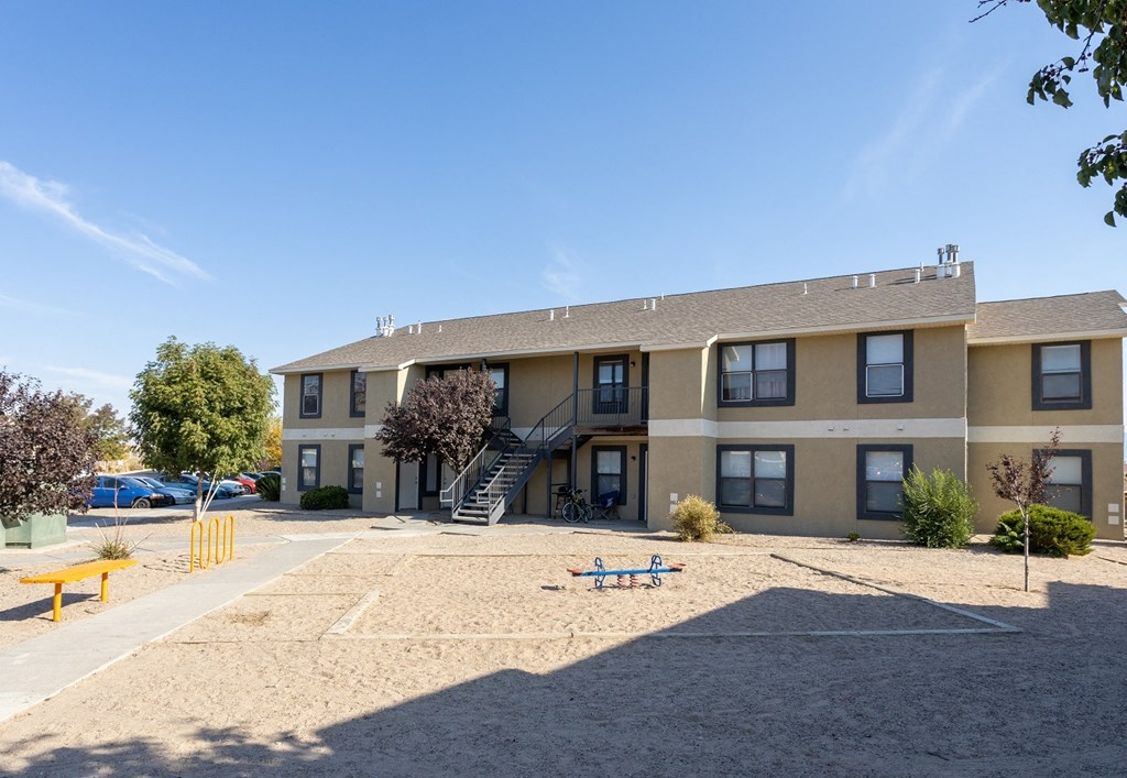 an apartment building with a playground in front of it