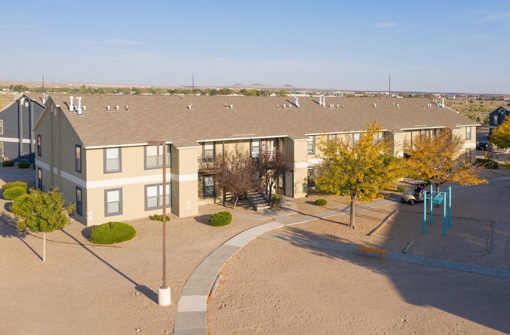 an aerial view of an apartment complex with a playground and a parking lot