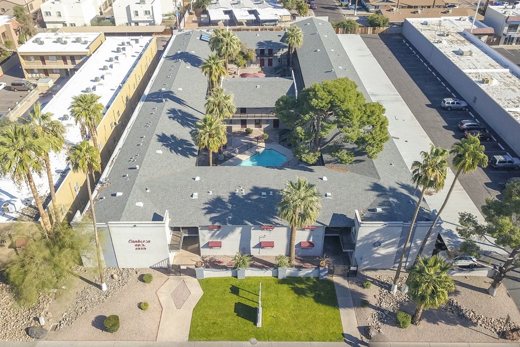 an aerial view of a house with a pool and palm trees