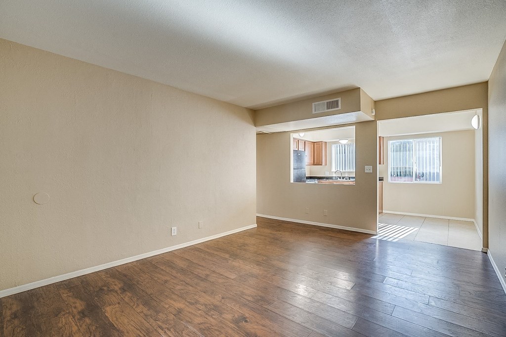 the living room and dining room of an empty apartment