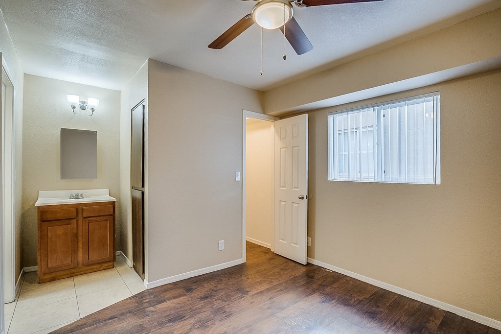 an empty bathroom with a ceiling fan and a sink