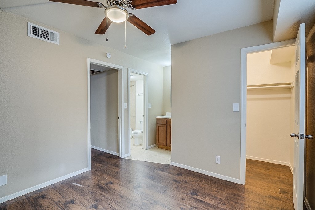 an empty living room with a ceiling fan