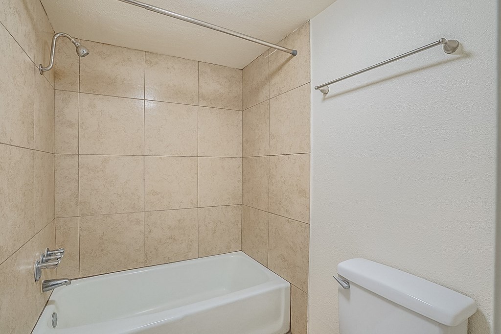 a bathroom with a toilet and a tub and a sink