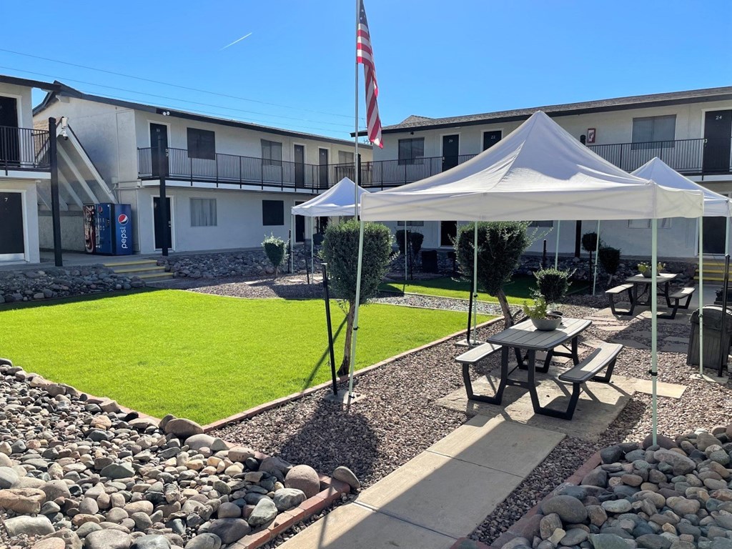 a courtyard with a picnic table and a tent