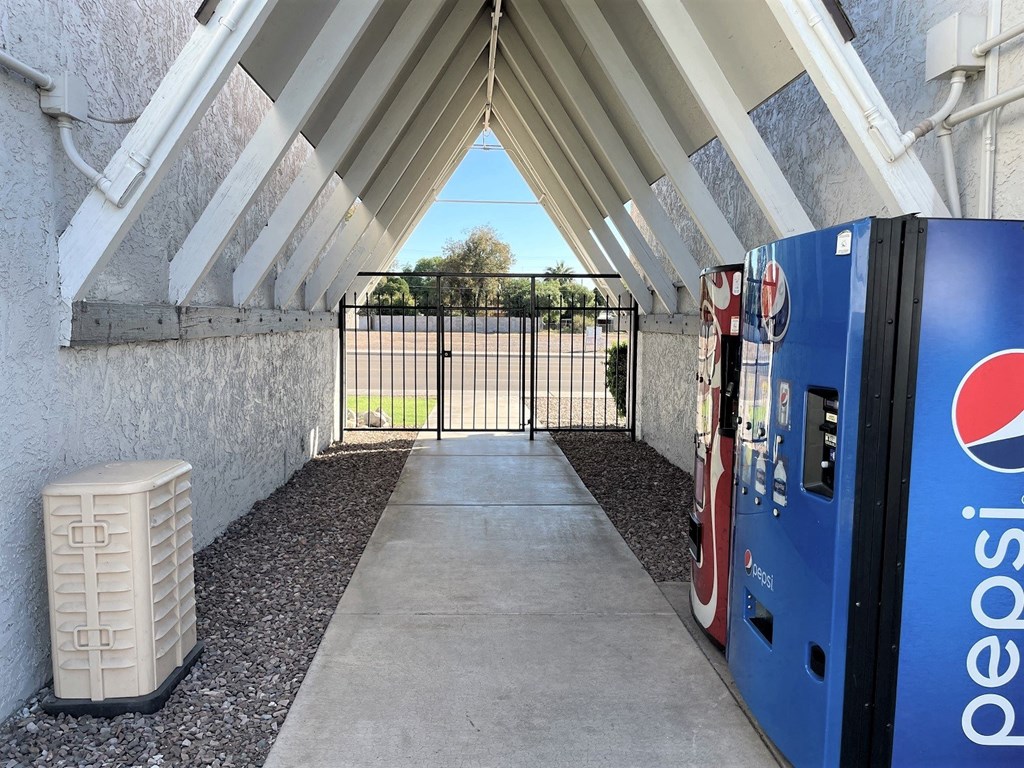 a vending machine outside of a building with a gate