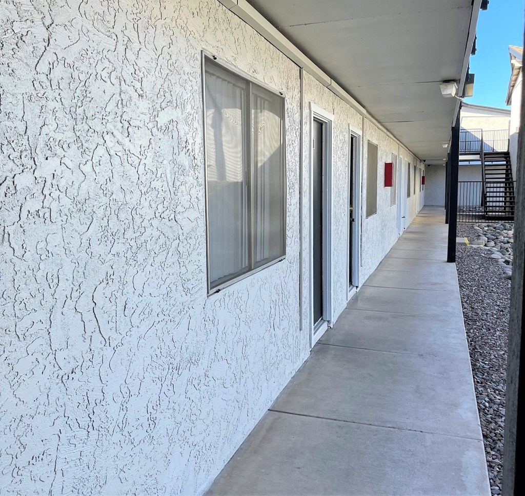 the side of a building with windows and a sidewalk